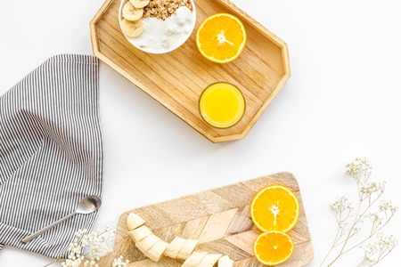 granola with banana slices and orange juice for breakfast on blue background top viewの写真素材