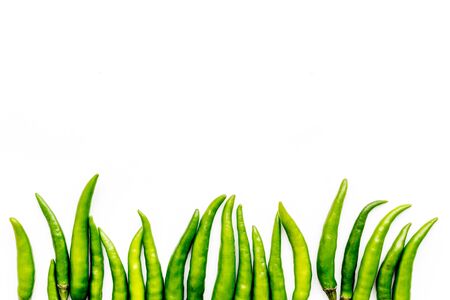 Food ingredients. Fresh green chilli pepper pattern on white table  top view space for textの写真素材