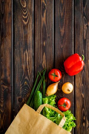 Healthy food with fresh vegetables in paper bag on wooden  top view space for textの写真素材