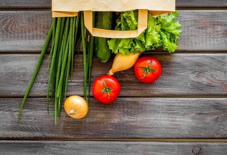 Healthy food with fresh vegetables in paper bag on wooden background top viewの写真素材