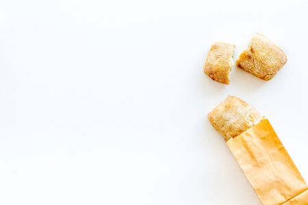 Fresh baguette and paper bag for bakery on white background top view mock-up