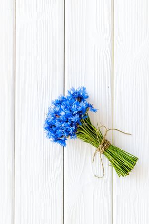 Summer. Field flowers design with bouquet of blue cornflowers on white wooden background top view space for textの写真素材
