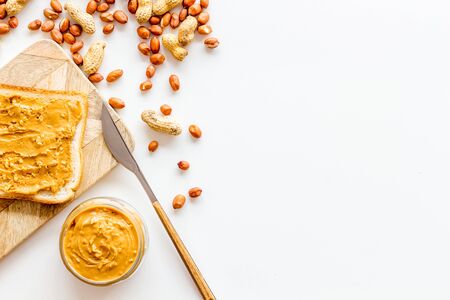 Make sandwiches with peanut butter in glass bowl on white  top view copyspace