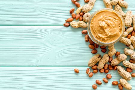 Peanut butter for cooking breakfast at home on mint green wooden  top view mock up.