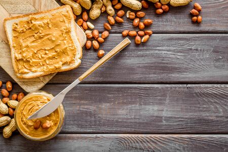 peanut butter for cooking breakfast with sandwiches at home on wooden background top view mock-up.