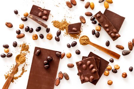 Cook homemade chocolate with bars, nuts, coffee beans on white background top view