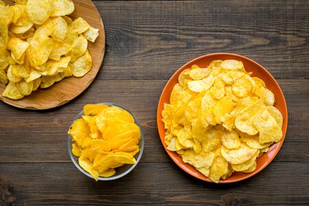 Potato crisps on wooden background top viewの写真素材