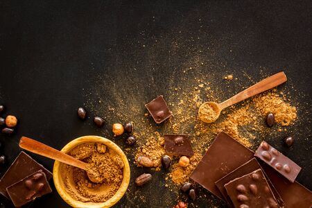Different variety of chocolate and hazelnut on black background top view space for textの写真素材