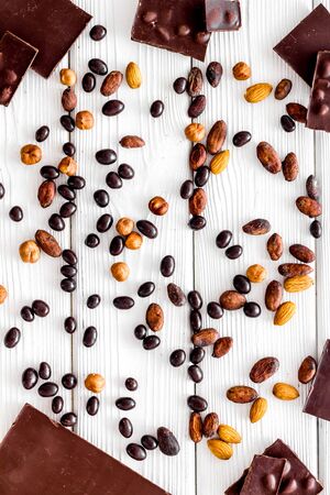Different variety of chocolate and hazelnut on white wooden background top viewの写真素材
