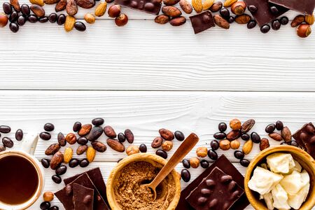 Chocolate with nuts and its ingredients on white wooden background top view copyspaceの写真素材