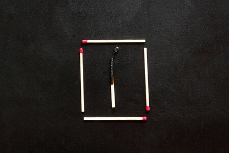 Symbol of danger with matches on black background top view