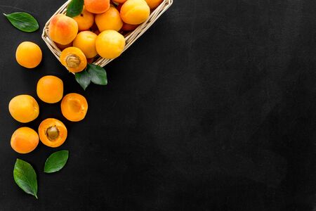 Collect apricots, black background top view space for text, pattern with leaves