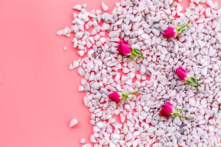 Decoration with stones and flowers on pink background top view copyspaceの写真素材