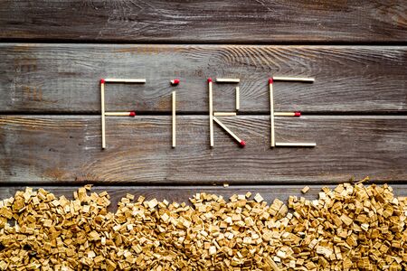 Protection of ecology. Fire in woodes concept with fire text and kindling frame on wooden background top viewの写真素材