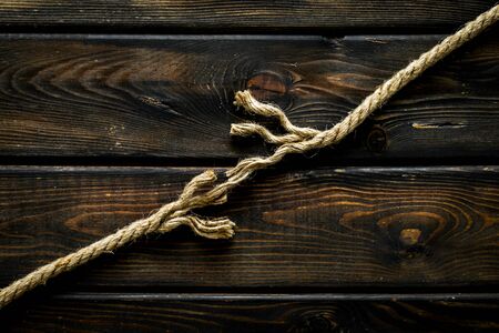 risk concept with rope near to break on wooden background top view space for text.