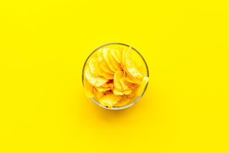 Junk food. Potato chips in bowl ready to eat on yellow background top viewの写真素材