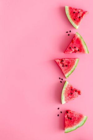 Summer snack. Cut watermelon for break with fruit on pink background top view mockupの写真素材