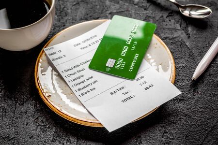 restaurant bill paying by credit card for cup of coffee on dark table backgroundの写真素材
