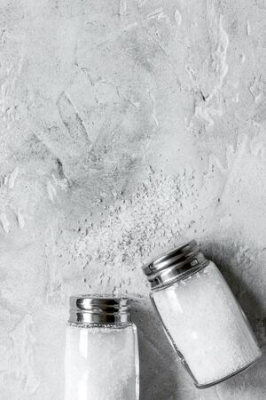 salt in glass bottle on gray kitchen table background top view space for textの写真素材