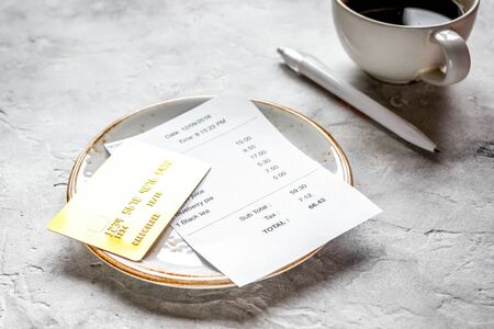 cup of coffee and receipt bill for payment by credit card on stone table backgroundの写真素材