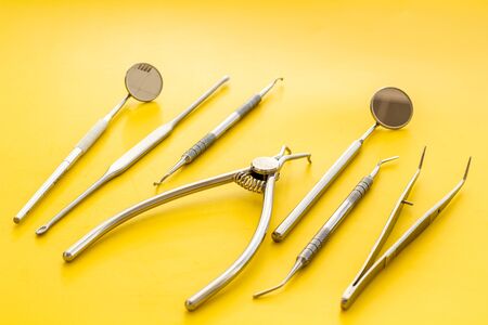 Dental instruments - set with mirrors - on yellow background close up.の写真素材
