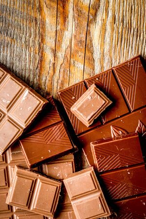 black and milk chocolate bars on dark wooden table background top view mockupの写真素材