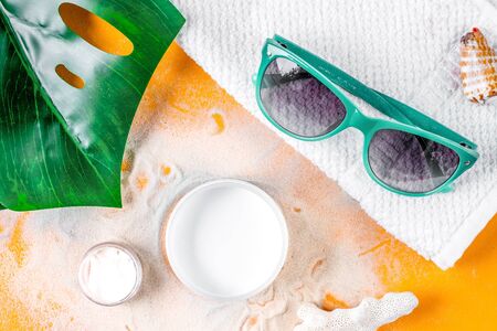 Summer cosmetic set with protection cream on orange background top viewの写真素材