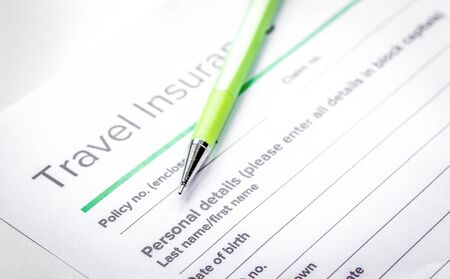 Traveling concept with insurance application on white tableの写真素材