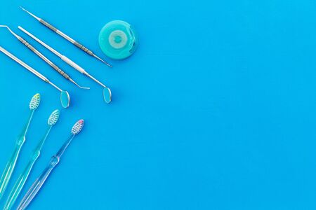 Dental care concept. Stomatological tools frame - with floss - on blue background top-down frame space for textの写真素材