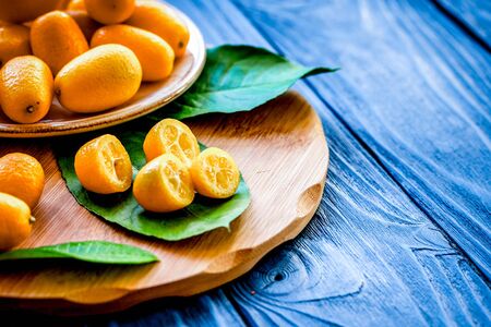 kumquat on plate at wooden tableの写真素材