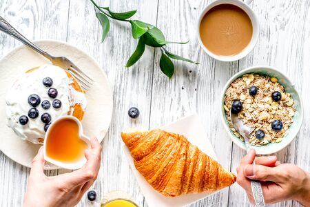 Breakfast concept with flowers on wooden background top view.