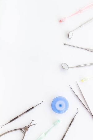Dental care concept. Stomatological tools frame - with floss - on white background top-down frame copy spaceの写真素材