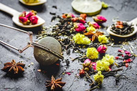 Tea herbs and spoons on grey stone backgroundの写真素材