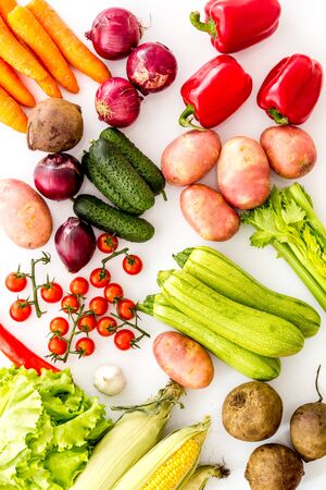 Fresh vegetables still life. Potato, cucumber, beet carrot, greenery on white background top-down.の写真素材