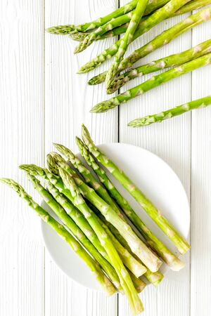 Fresh asparagus on plate on white woodenの写真素材