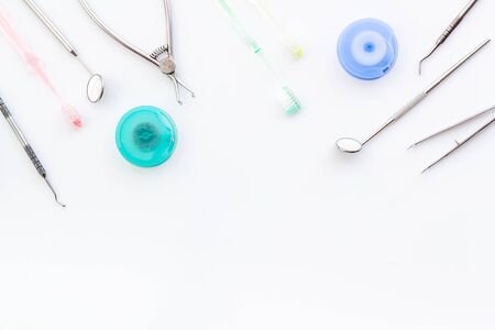 Dental care concept. Stomatological tools frame - with floss on whiteの写真素材