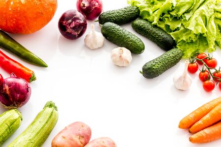 Autumn harvest. Vegetables - potato,cucumber, corn, greenery - frame on white background top-down.の写真素材