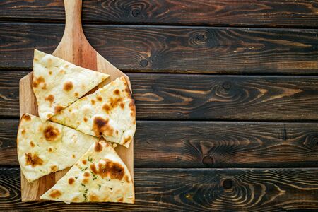 Make focaccia. Traditional italian bread on cutting board on dark wooden table top-down copy spaceの写真素材
