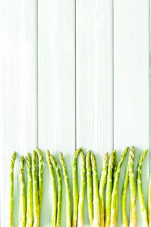 Asparagus steams frame on white wooden background top-down copy spaceの写真素材
