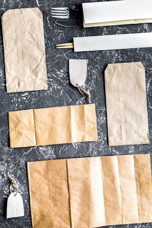 food delivery with paper bags and flatware gray background top view mockupの写真素材