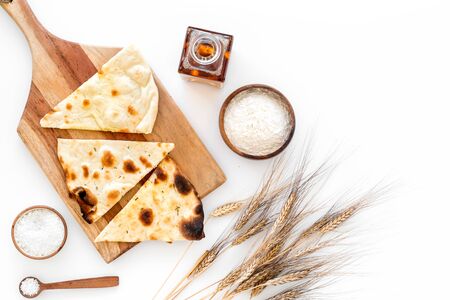 Focaccia ingredients. Wheat ears, flour, oil near bread on white background top-downの写真素材
