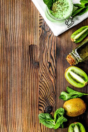 woman homemade cosmetic set with organic kiwi scrub, oil and mint on wooden table background top view mock upの写真素材