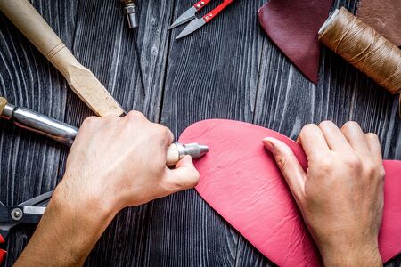 work in leather shop on dark wooden background top viewの写真素材