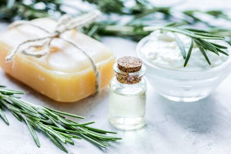 Rosemary essential oil in glass bottle in cosmetic set on table backgroundの写真素材