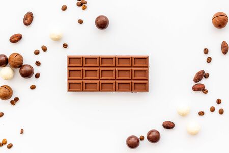 Candy background with chocolate on white table top view frame. Sweets desserts concept.