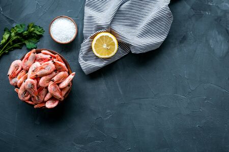 Shrimps for mediterranean salad - with lemon and greeenery - on grey desk top view copy spaceの写真素材