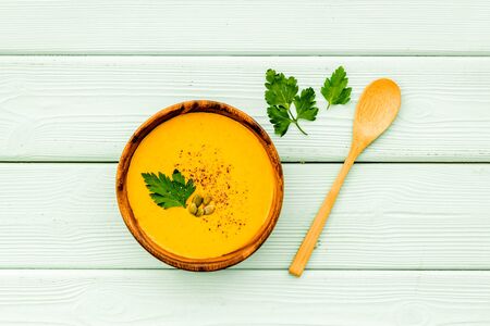 Pumpkin cream soup on green wooden table top view. Autumn meal.の写真素材
