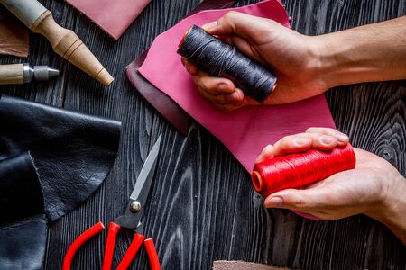 Work in leather shop on dark wooden