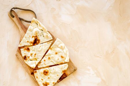 Make focaccia. Traditional italian bread on cutting board on beige table top-down copy spaceの写真素材