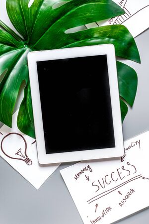 company strategy development management with tablet and success text in business set on gray office desk background top view mockupの写真素材